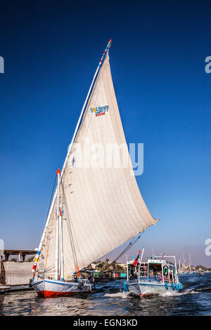 Eine Fähre und Feluke nehmen Touristen über den Nil in Luxor. Stockfoto