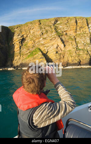 Junges Paar Vogelbeobachtung auf einer Bootstour in Scapa Flow, Orkney Inseln, Schottland. Stockfoto