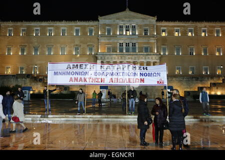 Athen, Griechenland. 27. Februar 2015.  Ein Banner steht außerhalb des griechischen Parlaments fordern Rückzug aus der EU und die Einziehung der Forderung. Tausende von Griechen folgten dem Aufruf der kommunistischen Partei von Griechenlands (KKE) trotz starken Regens, um gegen die Politik der griechischen Regierung zu protestieren, die weiterhin der Sparpolitik zu folgen, wie von der Eurogruppe, trotz unterschiedlicher Wahlversprechen gefordert. Bildnachweis: Michael Debets/Alamy Live-Nachrichten Stockfoto