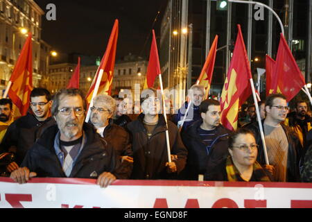 Athen, Griechenland. 27. Februar 2015.  Mitglieder der kommunistischen Partei Griechenlands marschieren mit roten Fahnen auf dem Syntagma-Platz. Tausende von Griechen folgten dem Aufruf der kommunistischen Partei von Griechenlands (KKE) trotz starken Regens, um gegen die Politik der griechischen Regierung zu protestieren, die weiterhin der Sparpolitik zu folgen, wie von der Eurogruppe, trotz unterschiedlicher Wahlversprechen gefordert. Bildnachweis: Michael Debets/Alamy Live-Nachrichten Stockfoto
