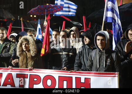 Athen, Griechenland. 27. Februar 2015. Menschen hören Sie die Rede des Generalsekretärs der KKE Dimitris Koutsoumpas, mit roten Fahnen und griechische Fahnen. Tausende von Griechen folgten dem Aufruf der kommunistischen Partei von Griechenlands (KKE) trotz starken Regens, um gegen die Politik der griechischen Regierung zu protestieren, die weiterhin der Sparpolitik zu folgen, wie von der Eurogruppe, trotz unterschiedlicher Wahlversprechen gefordert. Bildnachweis: Michael Debets/Alamy Live-Nachrichten Stockfoto