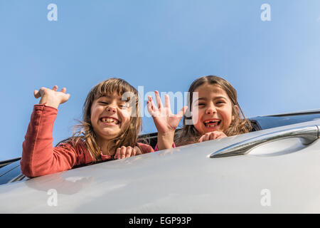Zwei Schwestern Antritt einer Reise und winkt aus dem Auto Stockfoto