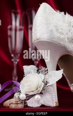 Trauringe auf dem Hintergrund eines Paares von Weinglas als Hintergrund Stockfoto