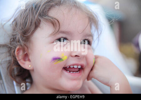 Porträt eines glücklichen Babys mit Farbe im Gesicht Stockfoto