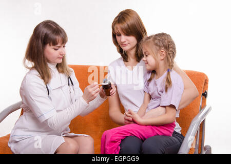 Arzt Kinderarzt untersucht ein krankes Kind zu Hause im Beisein meiner Mutter Stockfoto