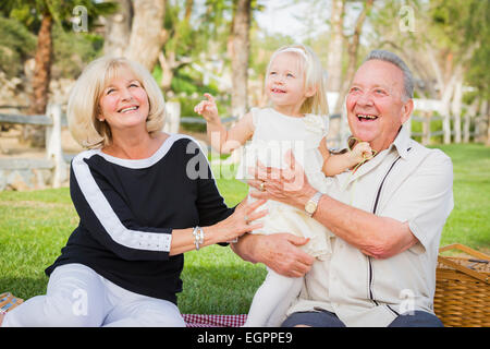 Liebevolle Enkelin und Großeltern spielen draußen im Park. Stockfoto