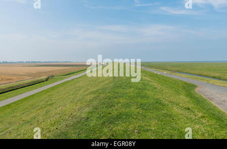 Grass Deich in Groningen mit breiten Landscap und blauer Himmel. Stockfoto