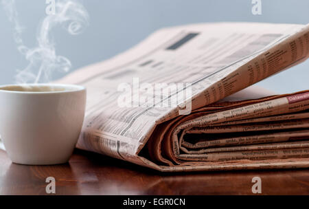 Zeitung und Kaffee auf Holztisch Stockfoto