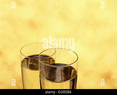 Zwei Gläser mit Champagner als Eheringe Symbol, der Hintergrund jedoch unscharf Stockfoto