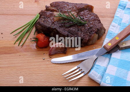 Rib-Eye Steak, Cherry-Tomaten, Knoblauch, Kräuter auf hölzernen Hintergrund Stockfoto