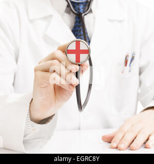 Arzt-Holding-Stethoskop mit Flagge - England Stockfoto
