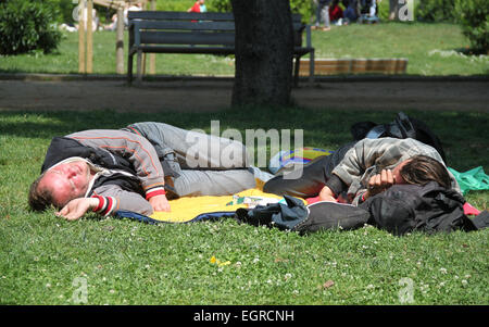 Zwei Männer liegen und schlafen auf dem Rasen in Ciutadella Park, Barcelona, Katalonien, Spanien Stockfoto