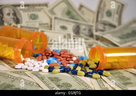 3 Flaschen von Pillen, die ein Haufen von hundert-Dollar-Scheine übergreifen Stockfoto