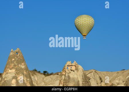 Heißluftballon fliegen über Tuffstein Felsformationen und uralte Höhle Wohnungen, Göreme, Kappadokien, Türkei Stockfoto