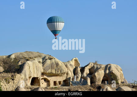 Heißluftballon fliegen über Tuffstein Felsformationen und uralte Höhle Wohnungen, Göreme, Kappadokien, Türkei Stockfoto