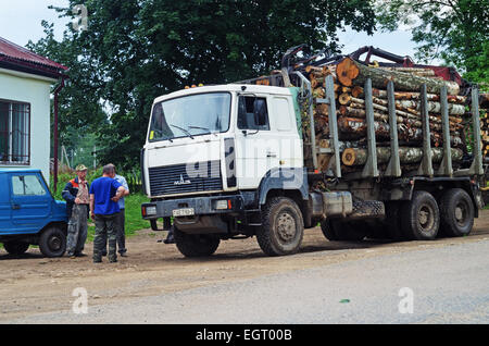 Transport von Schnittholz per LKW. Der LKW mit Protokollen auf dem Parkplatz in der Nähe von Dorfladen. Stockfoto