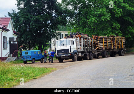 Transport von Schnittholz per LKW. Der LKW mit Protokollen auf dem Parkplatz in der Nähe von Dorfladen. Stockfoto