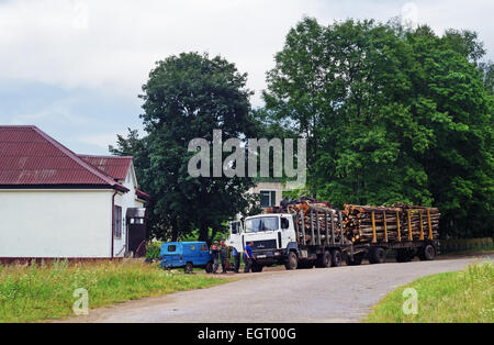 Transport von Schnittholz per LKW. Der LKW mit Protokollen auf dem Parkplatz in der Nähe von Dorfladen. Stockfoto