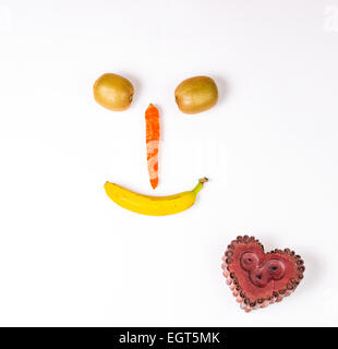 Dieser Smiley ist Wirh Karotte, Kiwi und Banane, unten Herz Kerze gemacht. Stockfoto