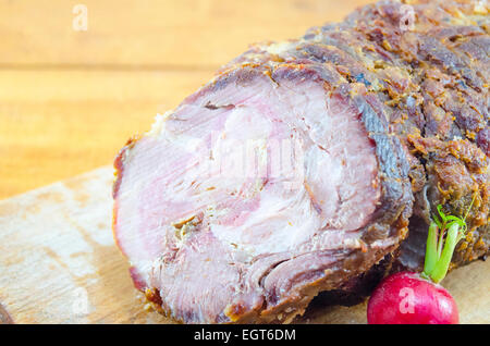 Gefüllte gebratenes Schweinefleisch auf ein Schneidebrett, dekoriert mit Radieschen Stockfoto