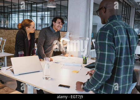 Erfolgreiche Geschäftskollegen zusammenstehen in einer Sitzung. Gemischtrassig Kreativteam arbeiten im stehen diskutieren. Stockfoto