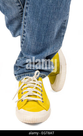 Auffällige gelbe Leinwand Turnschuhe und Jeans. Stockfoto