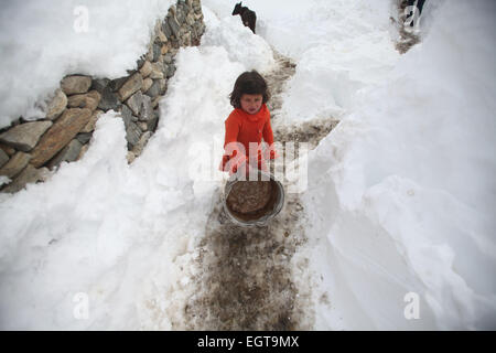 Panjshir, Afghanistan. 1. März 2015. Ein afghanische Kind geht auf dem Schnee neben ihrem zerstörten Haus nach Lawinen in Abdullah Khil von Panjshir Provinz, Afghanistan, 1. März 2015. Afghanische Regierung und Hilfe Agenturen haben verstärkt Bemühungen um die Soforthilfe für die Opfer der tödliche Lawinen in Panjshir Ostprovinz. © Ahmad Massoud/Xinhua/Alamy Live-Nachrichten Stockfoto