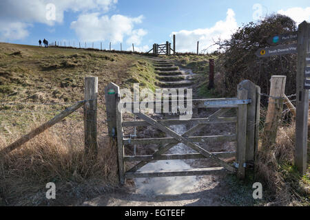 Wanderer in den sieben Schwestern Country Park machen ihren Weg den Hang entlang der South Downs Way. Stockfoto