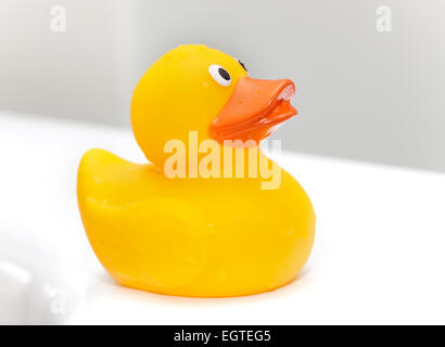 Süße Gummiente auf dem Rand der Badewanne. Stockfoto