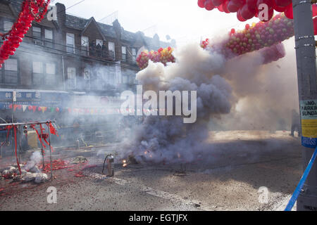 Straße wird während der Zeremonie Feuerwerkskörper an Chinese New Year im Abschnitt "Chinatown" von Brooklyn, NY in Rauch gehüllt. Chinesische Leute aus der Nachbarschaft Chinatown/Sunset Park, Brooklyn, NY feiern Chinese New Year mit einer Parade und Festival bringen in das Jahr von Ram, 2015 Stockfoto