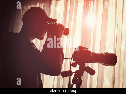 Mann mit Fernglas und Kamera-Steuerung jemand Stockfoto