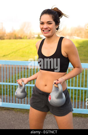 junge Frau Hanteln heben. Stockfoto