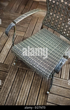 Stilvolle Wicker Sessel auf einer Holzterrasse Stockfoto