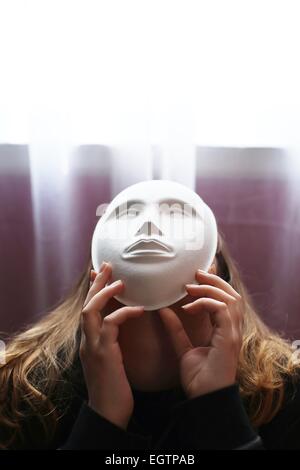 Ein Mädchen trägt eine Maske mit einer leeren Fläche. Stockfoto