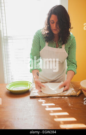 Frau Teig ausrollen. Stockfoto