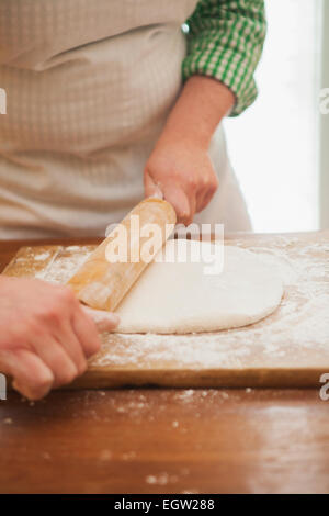 Frau Teig ausrollen. Stockfoto