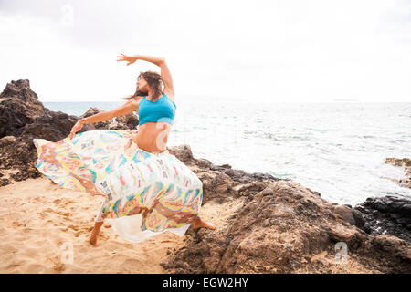 Frau, tanzen und springen am Strand. Stockfoto
