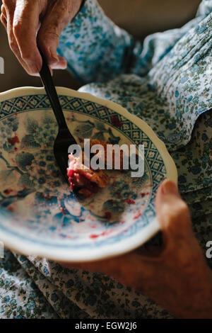 Nahaufnahme von senior Frauenhand Kuchen essen. Stockfoto