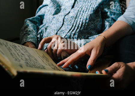 Ältere Frau und jüngere Frauenhand Blick durch eine Zeitschrift. Stockfoto