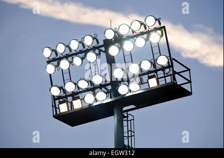 Fußball-Stadion-Scheinwerfer eingeschaltet bei Sonnenuntergang Stockfoto