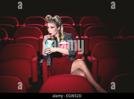 Frau im Kino allein, Popcorn Essen und trinken eine Cola. Stockfoto