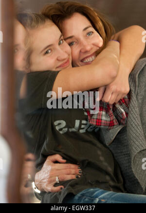 Mutter und Teen Tochter umarmt vor Spiegel. Stockfoto
