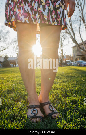 Frauenbeine mit Sonne dazwischen. Stockfoto