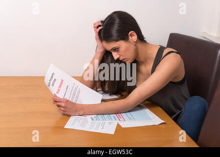 junge Studentin besorgt über unbezahlte Rechnungen und Studentendarlehen Stockfoto