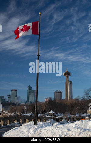 Niagara Falls, Ontario - eine kanadische Flagge fliegt in der Nähe von Niagara Falls. Der Skylon Tower, ein Casino und Hotels sind im Hintergrund. Stockfoto