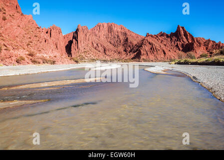 Fluss mit roten dramatischen Hügeln im Hintergrund in der Nähe von Tupiza, Bolivien Stockfoto