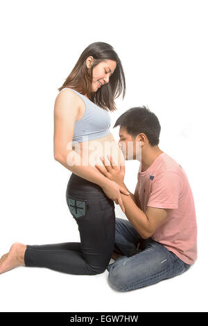Mann küssen schwangeren Bauch seiner Frau Stockfoto