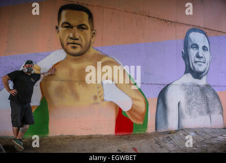 Ein Graffiti Künstler Farben ein Wandbild des bulgarischen Boxer Kubrat Pulev, aka The Cobra, an einer Wand unter einer Brücke zur Unterstützung der ungeschlagenen Schwergewichte-WM-Titel kämpfen gegen amtierende Weltmeister Wladimir Klitchko. Neben der Cobra ist ein Porträt des legenda Stockfoto