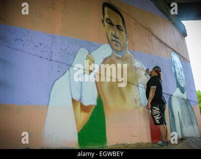 Ein Graffiti Künstler Farben ein Wandbild des bulgarischen Boxer Kubrat Pulev, aka The Cobra, an einer Wand unter einer Brücke zur Unterstützung der ungeschlagenen Schwergewichte-WM-Titel kämpfen gegen amtierende Weltmeister Wladimir Klitchko. Neben der Cobra ist ein Porträt des legenda Stockfoto