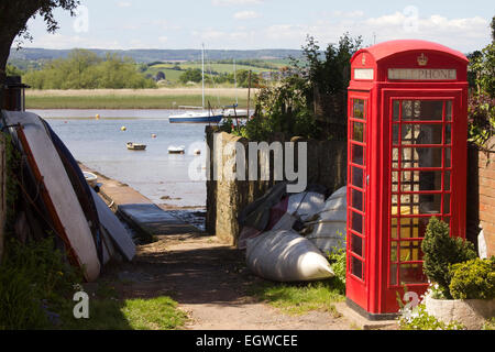 Britische rote Telefonzelle neben der Fluss Exe Mündung in das Dorf Topsham, Devon UK, mit Blick über den Fluss. Stockfoto